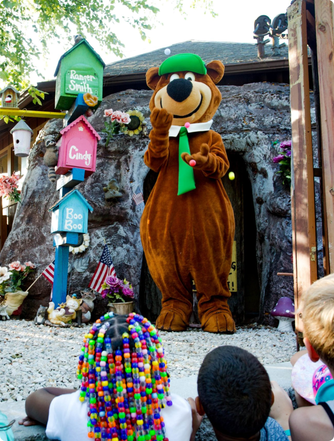 A brown bear mascot with a big smile
