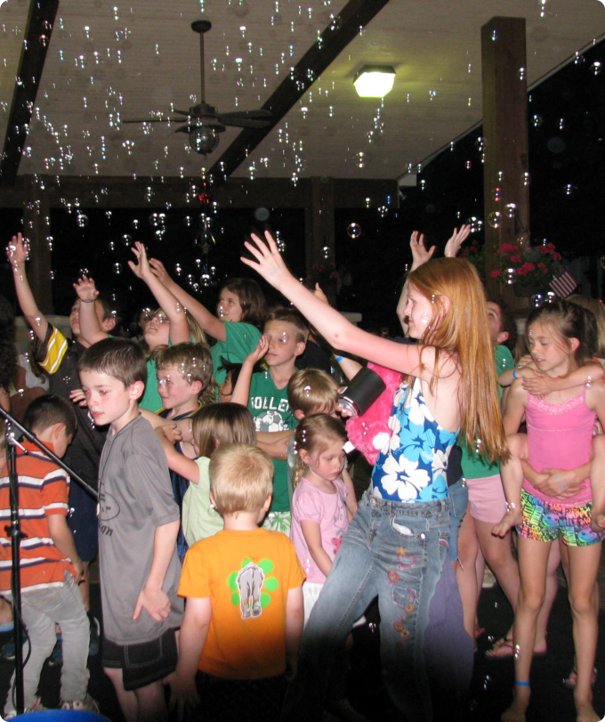 A diverse group of children smiling and playing together in a sunny park setting.