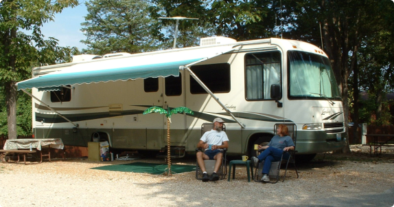 A couple of people sitting on a bench in a park