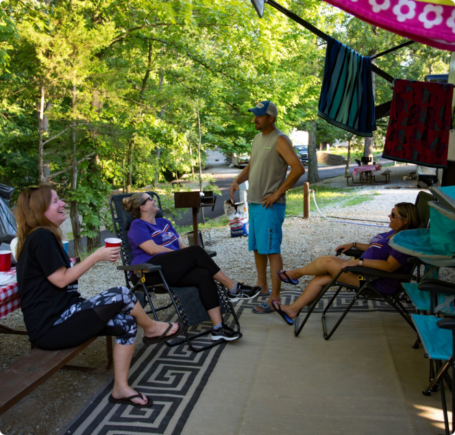 A diverse group of people enjoying a meal together at a picnic table in a park setting
