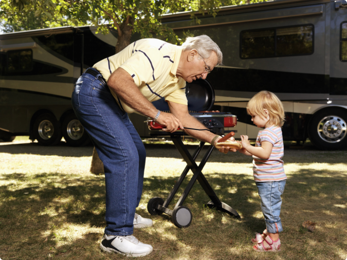 A man and a little girl smiling together in a park