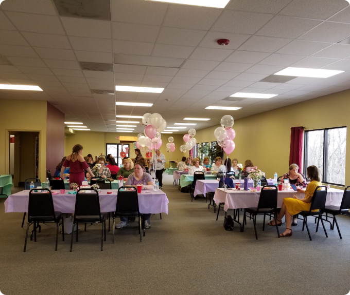 A group of people seated at tables in a well-lit room