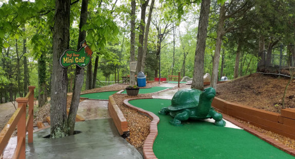 Outdoor mini golf course surrounded by trees