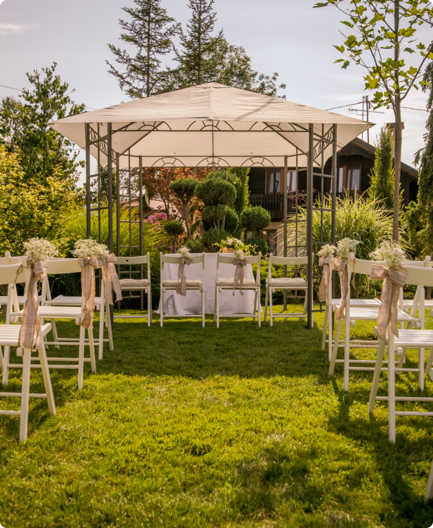 A white canopy drapes elegantly over a set of chairs