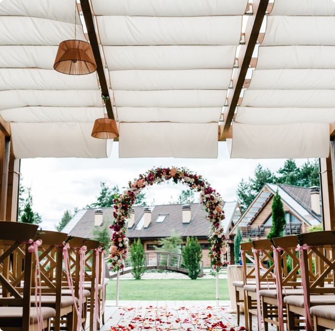 A wedding ceremony under a floral canopy