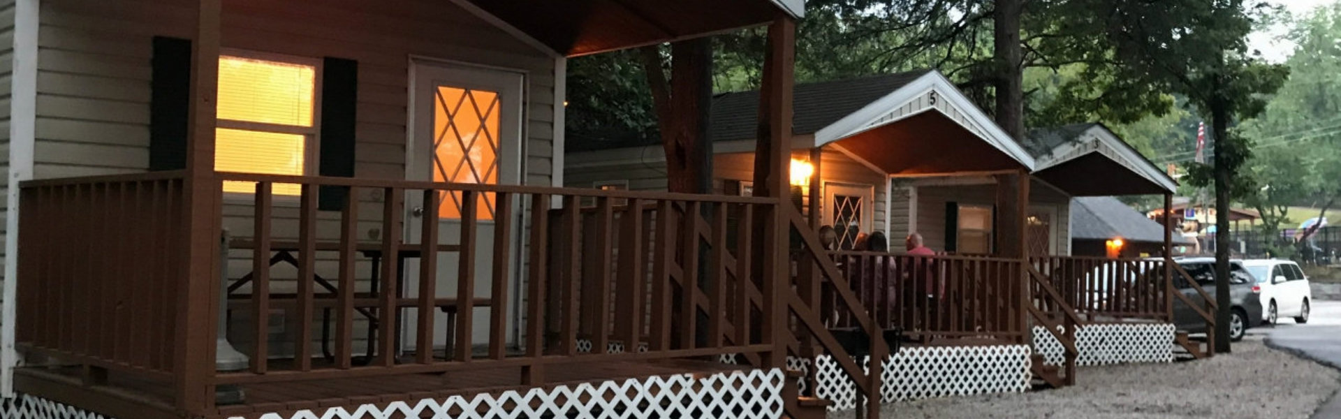 A row of small cabins featuring porches with lights