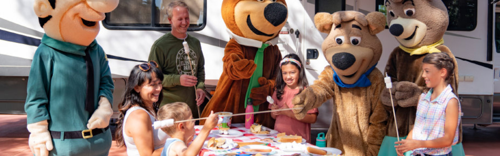 A group of people in bear costumes gathered around a picnic table